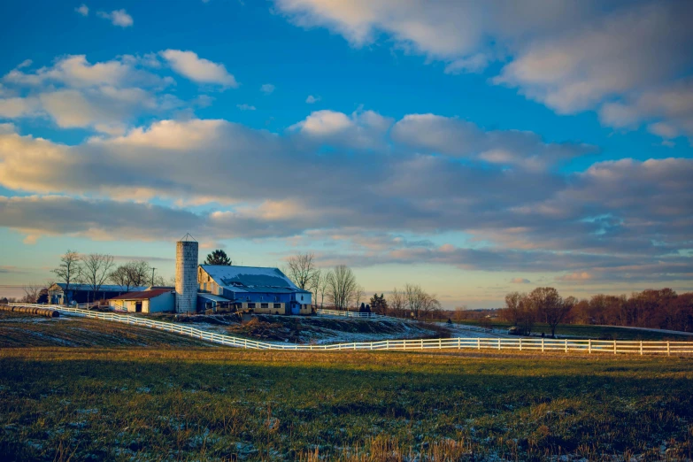 a large white barn sitting on top of a lush green field, by Robert Storm Petersen, pexels contest winner, winter setting, late afternoon, 2 0 2 2 photo, midwest town