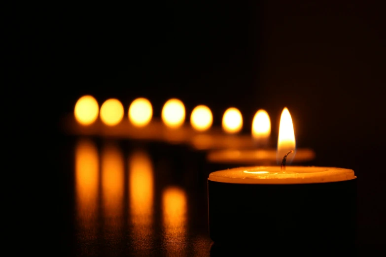 a row of lit candles in the dark, by Niko Henrichon, lightshow, remembrance, relaxing, amanda lilleston