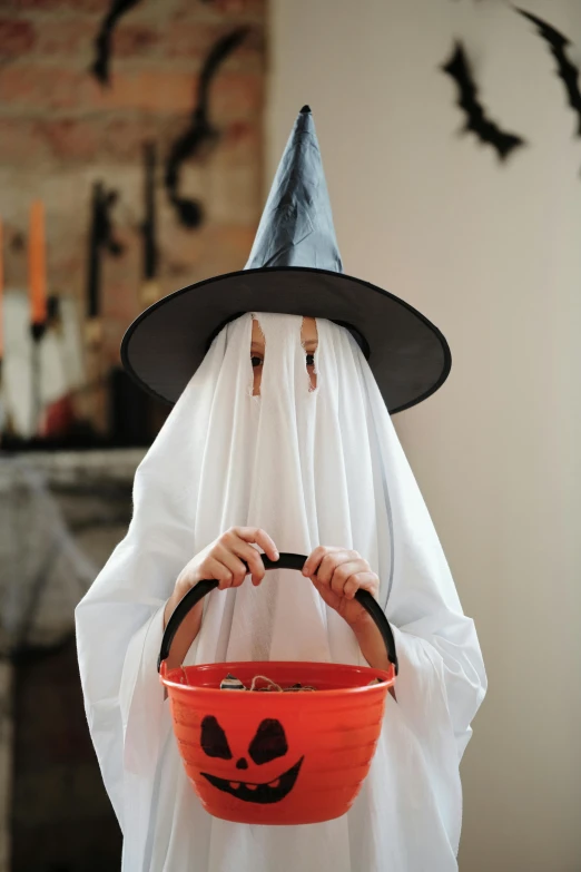 a person dressed as a ghost holding a bucket, helm, orange and white, medium, mist