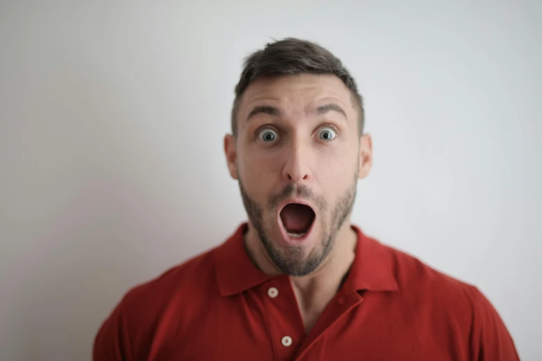a man with a surprised look on his face, pexels contest winner, light stubble with red shirt, someone is screaming, gif, square masculine jaw