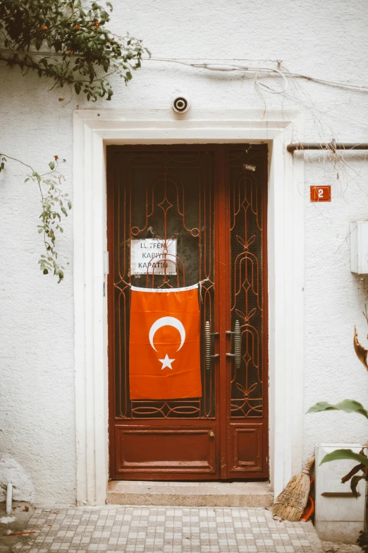 a door with a turkish flag on it, by Julia Pishtar, pexels contest winner, art nouveau, orange and white, 256x256, neighborhood themed, colonial