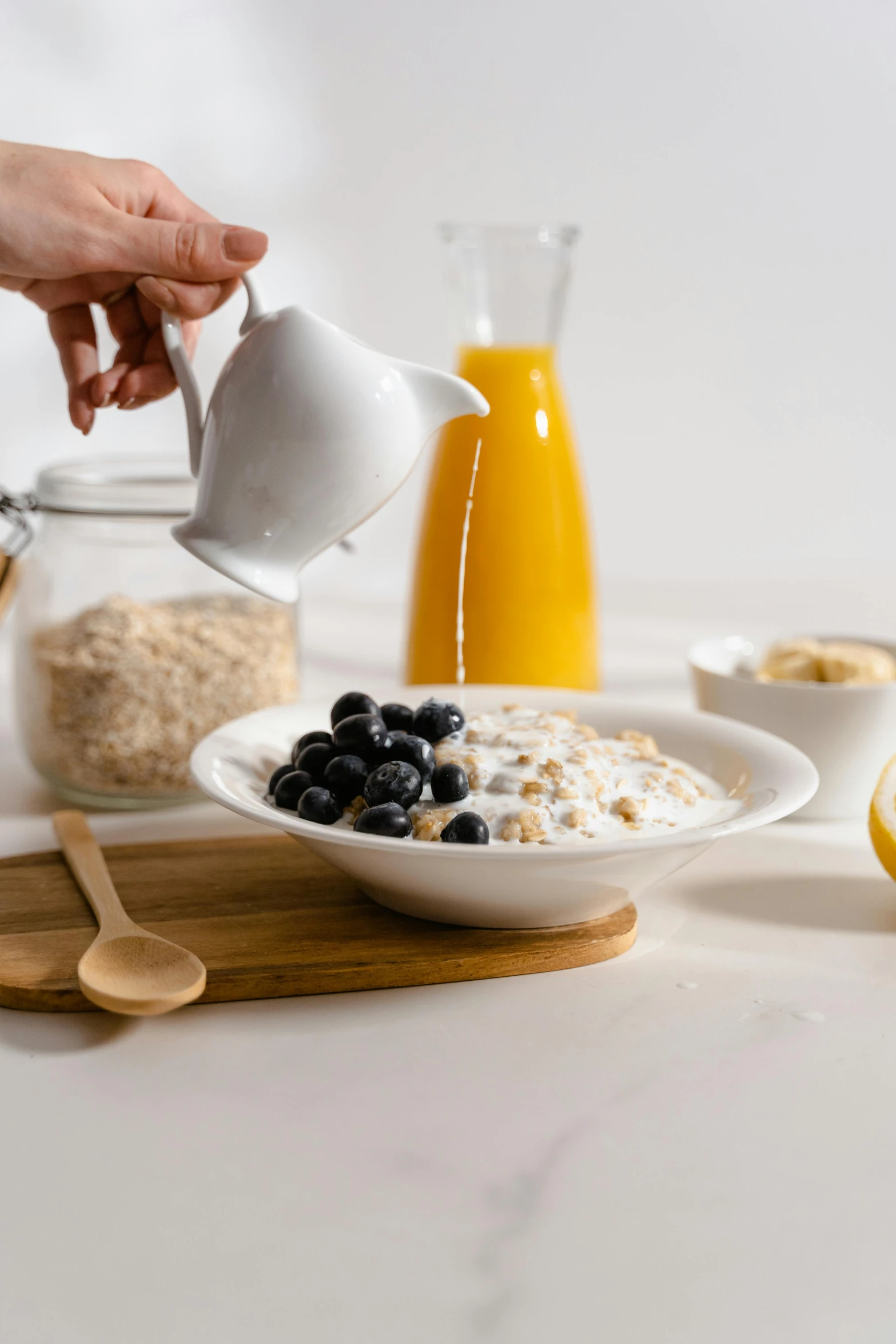 a person pouring milk into a bowl of oatmeal, a still life, trending on pexels, realism, plates of fruit, gif, grey, angled