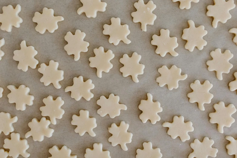 a bunch of cookies sitting on top of a cookie sheet, inspired by Rachel Whiteread, trending on pexels, snowflakes, pale beige sky, made of glazed, clover