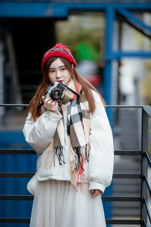 a woman taking a picture with a camera, inspired by Ma Yuanyu, tartan scarf, 5 0 0 px models, 8k 50mm iso 10, high-quality photo