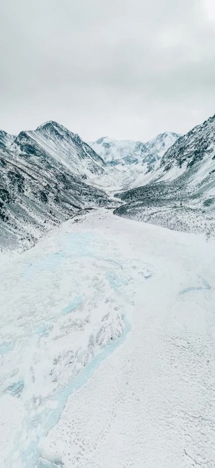 a man riding a snowboard down a snow covered slope, an album cover, pexels contest winner, land art, drone view, frozen river, glacier, profile image