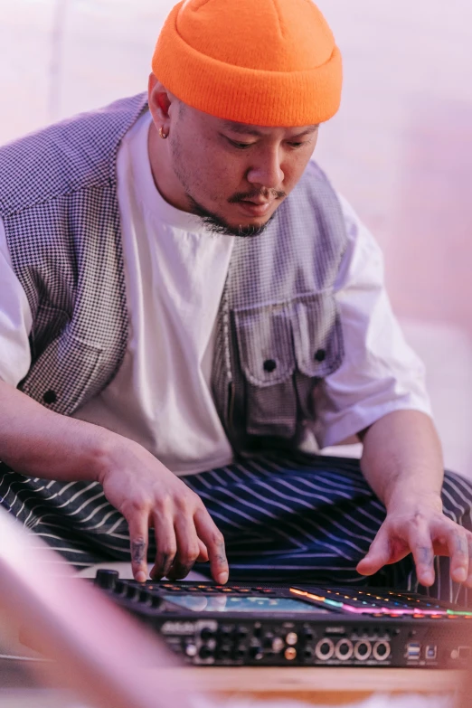 a man sitting on the ground working on a laptop, an album cover, inspired by Xia Yong, unsplash, ukiyo-e, xylophone, cooking, malaysian, close - up portrait shot