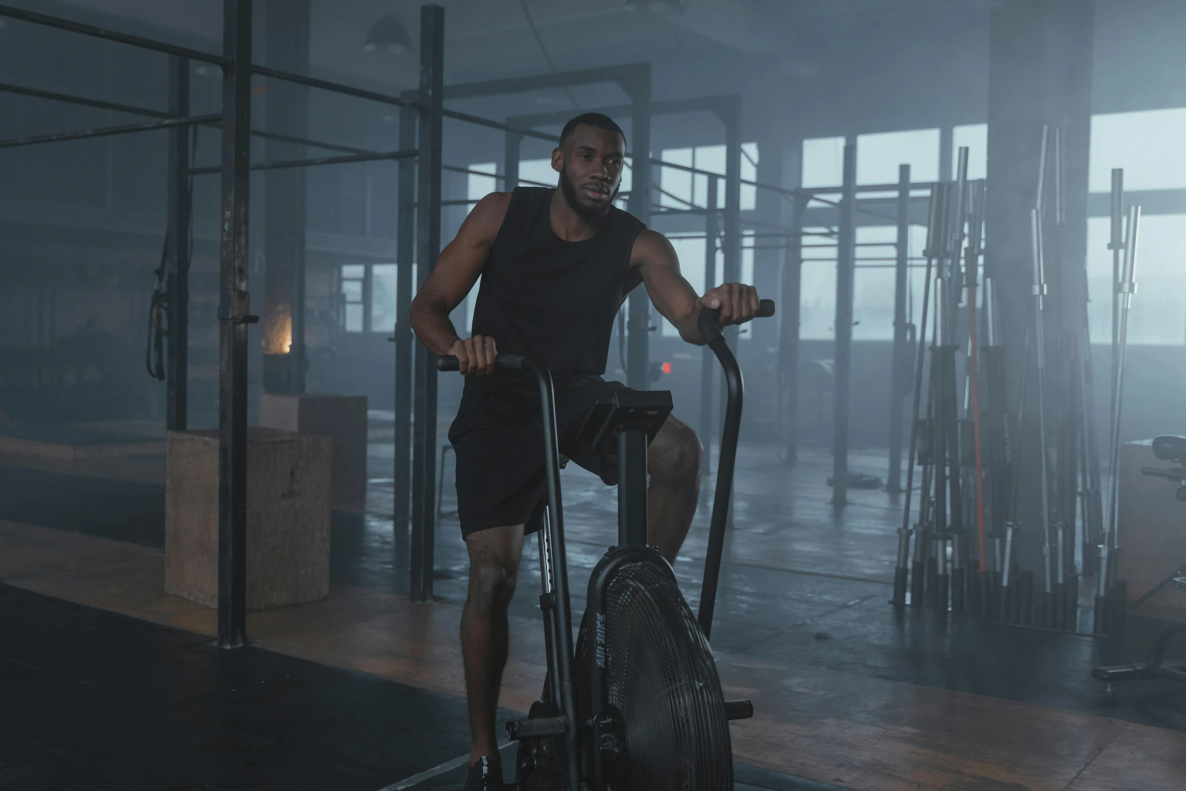 a man riding a stationary bike in a gym, a portrait, pexels contest winner, misting, real engine 5 cinematic, low quality photo, lamp ( ( ( gym ) ) ) )