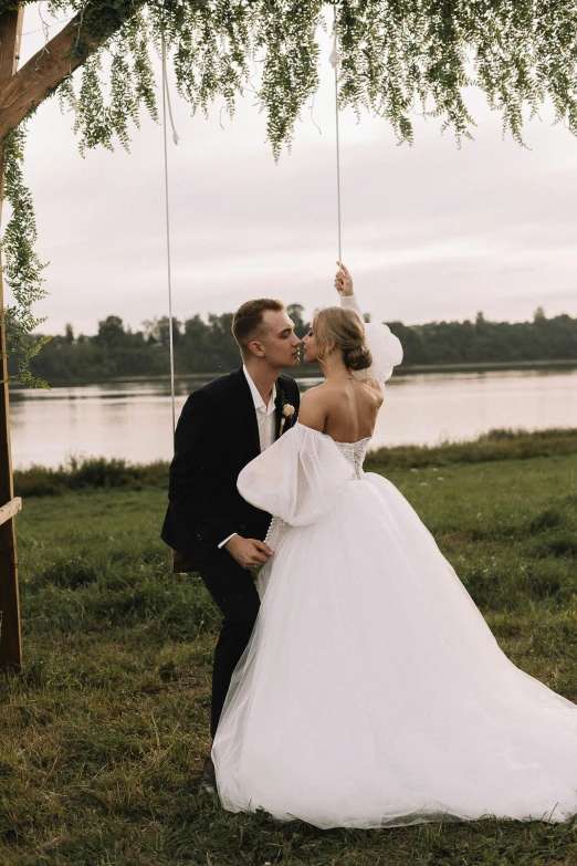 a bride and groom kissing under a tree, a picture, unsplash, romanticism, swings, lake view, gif, dasha taran
