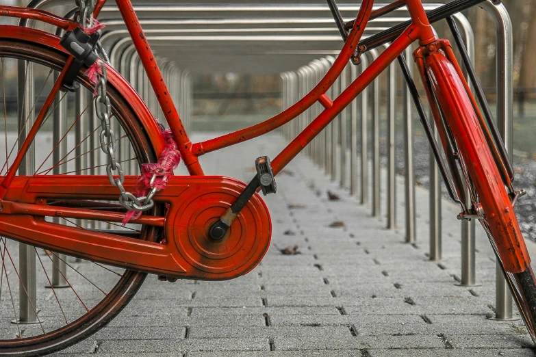 a red bicycle parked next to a metal fence