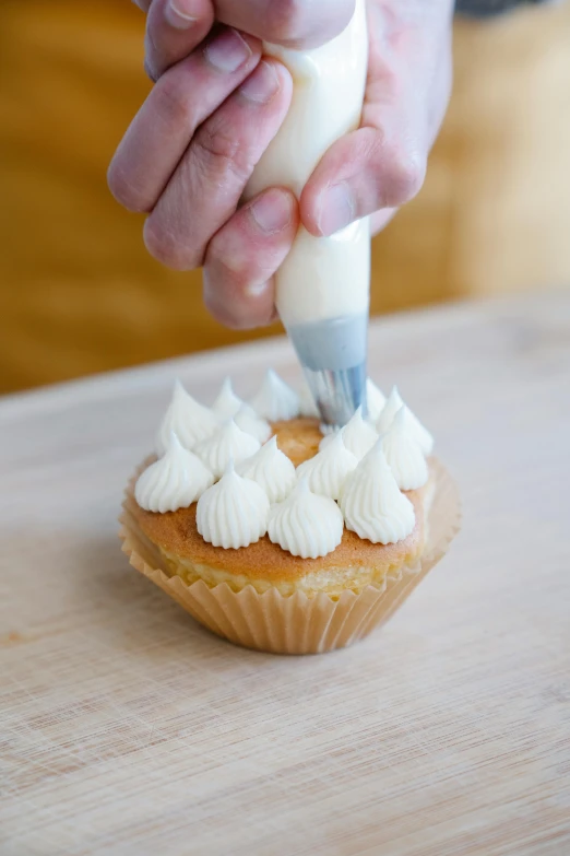 a person spreading icing icing on a cupcake, inspired by Gerard David, using the degrade technique, natural soft rim light, easy to use, thumbnail