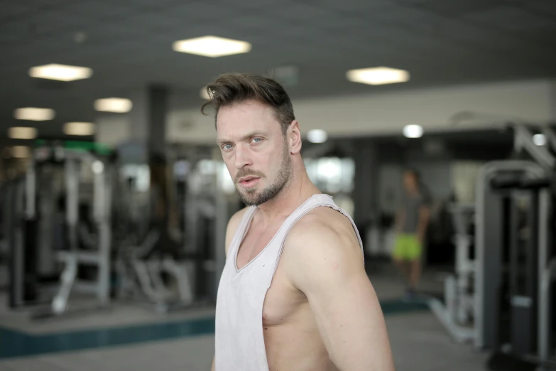 a man in a white tank top standing in a gym, a photo, avatar image, andrzej sykut, image