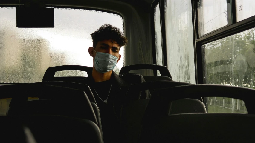 a man wearing a face mask on a bus, pexels contest winner, zayn malik, ariel perez, he is about 2 0 years old, surgeon