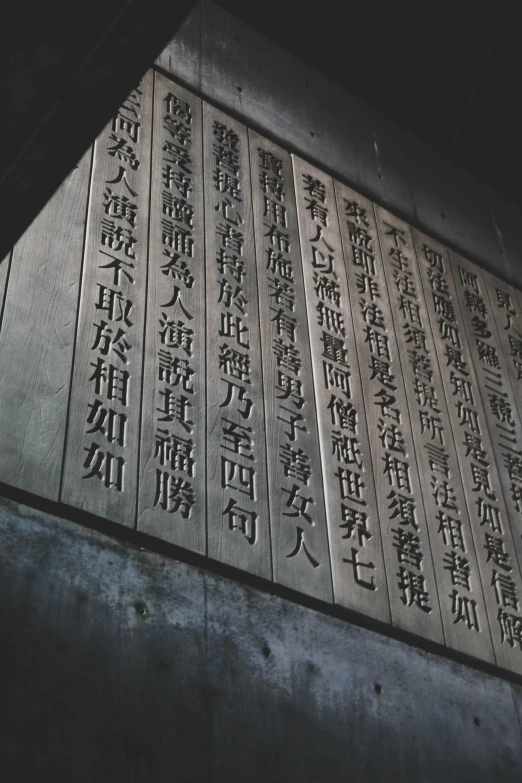 a close up of a wall with writing on it, a statue, inspired by Sesshū Tōyō, unsplash, on a gray background, ancient library, evening lighting, shanghai