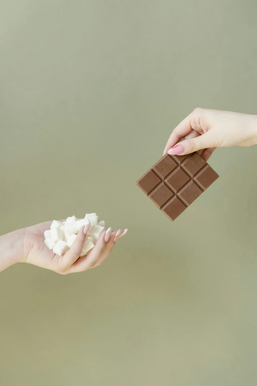 two hands reaching for a piece of chocolate, a picture, shutterstock, happening, marshmallow, square, clemens ascher, 15081959 21121991 01012000 4k