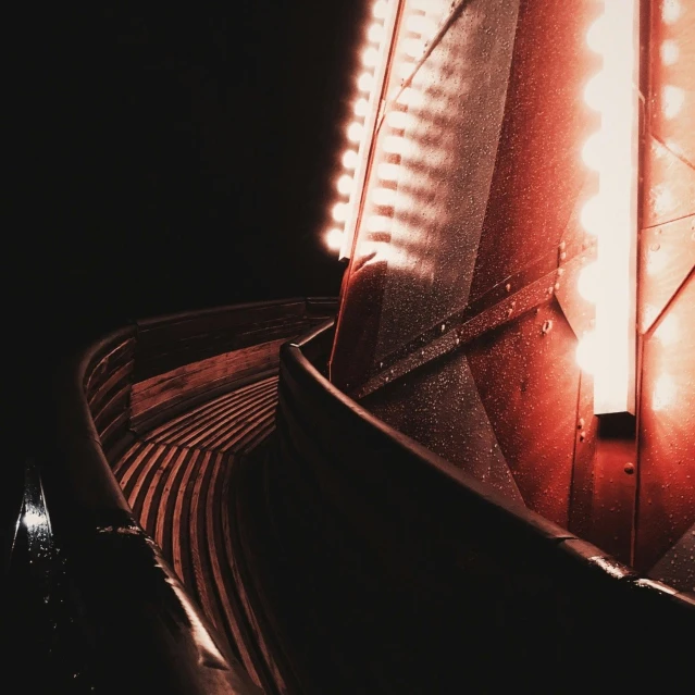 a light that is on the side of a building, an album cover, pexels contest winner, art photography, boat, black and red tones, vsco film grain, interior light