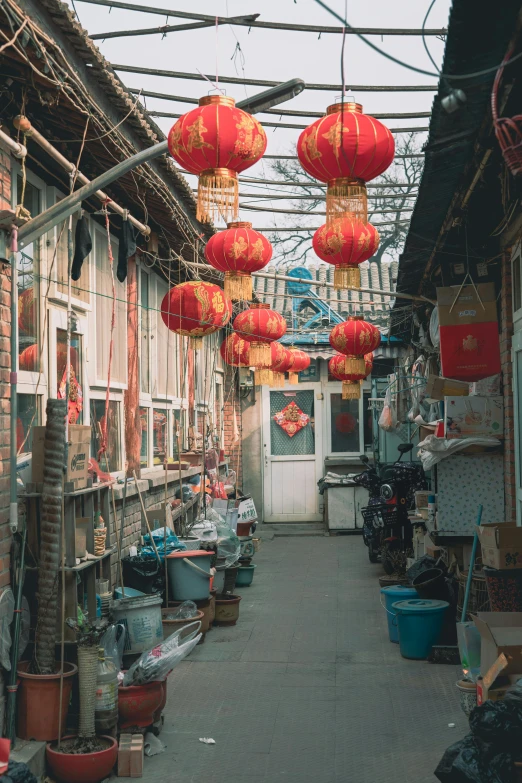 a narrow alley with lots of red lanterns hanging from the ceiling, a silk screen, settlement, color photo, square, rear-shot