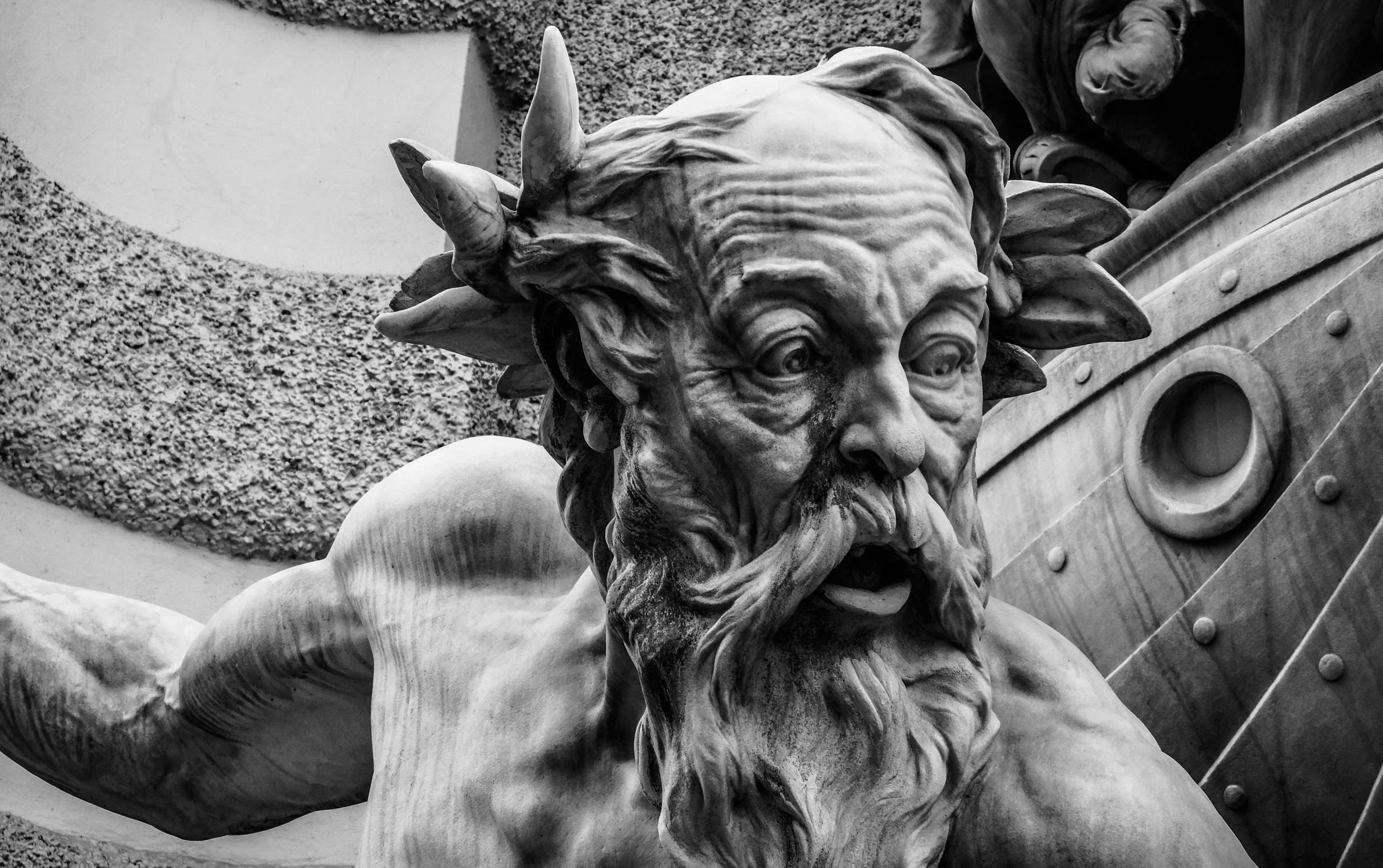 a black and white photo of a statue of a man, by Exekias, pexels contest winner, art nouveau, a devilish grin on his face, neptune, an oldman, myth