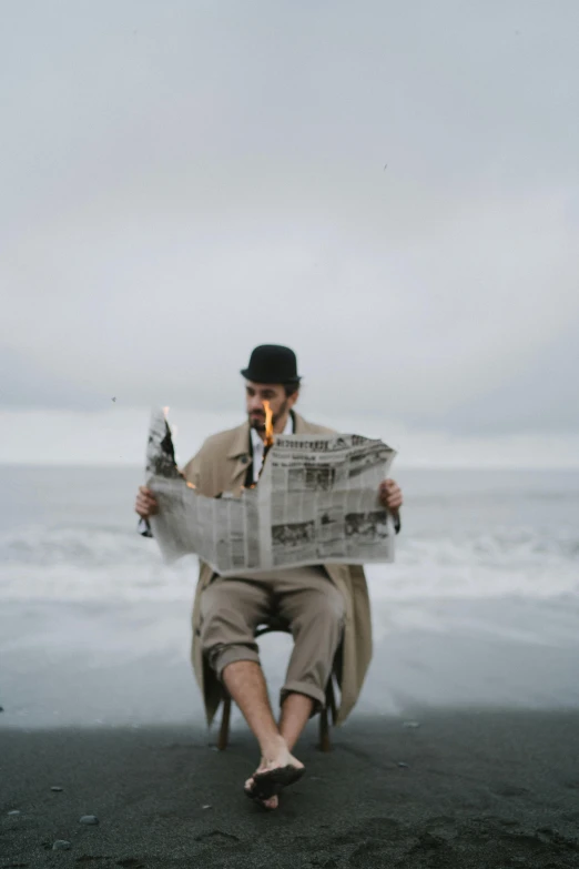 a man sitting on a beach reading a newspaper, unsplash, renaissance, smoke in front, old timey, in the ocean, cinematic outfit photo