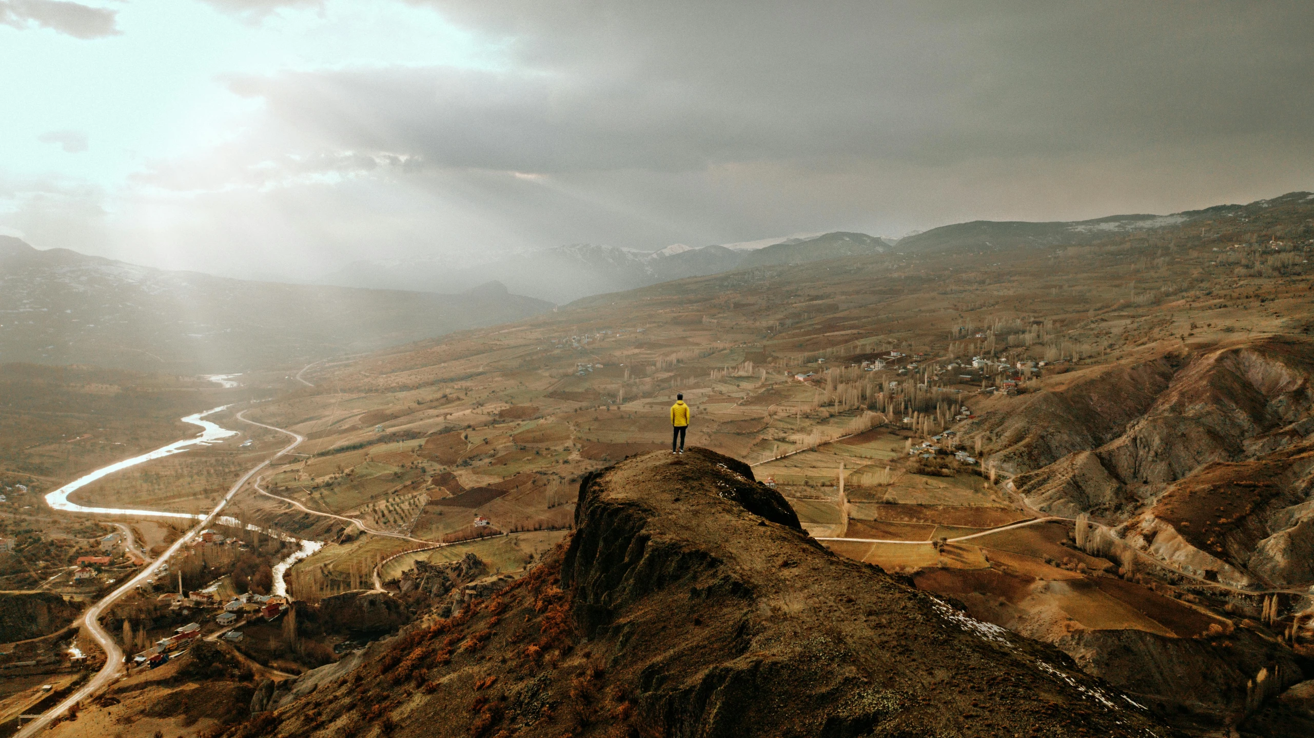 a person standing on top of a mountain overlooking a valley, by Muggur, pexels contest winner, les nabis, citadel of erbil, yellow, alessio albi, slide show