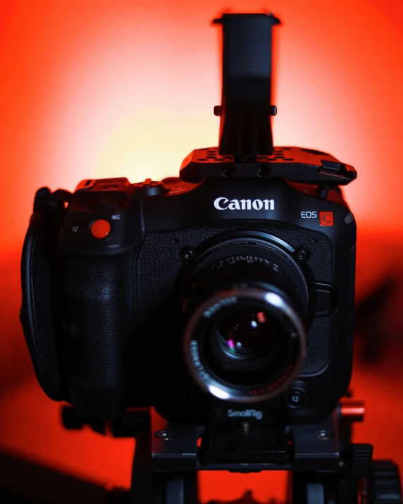 a close up of a camera on a tripod, lit from below with red lighting, canon on chest, instagram post, lut