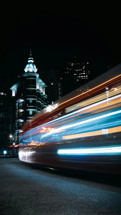 a blurry picture of a city street at night, by Sam Black, unsplash contest winner, hypermodernism, buses, high speed, square, san francisco