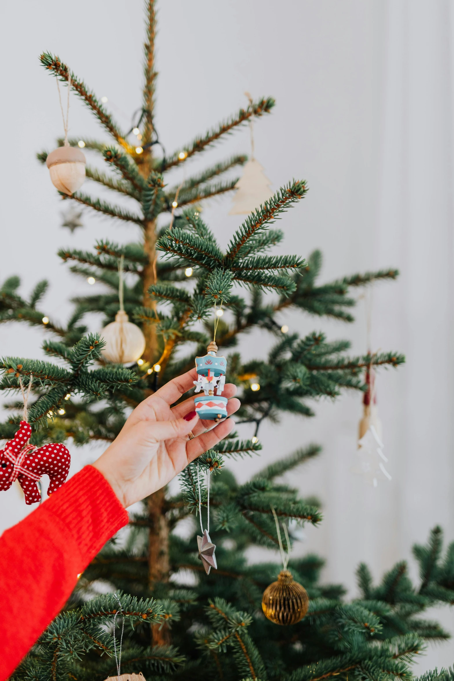 a woman decorating a christmas tree with ornaments, by Julia Pishtar, with small object details, view, small, cosy