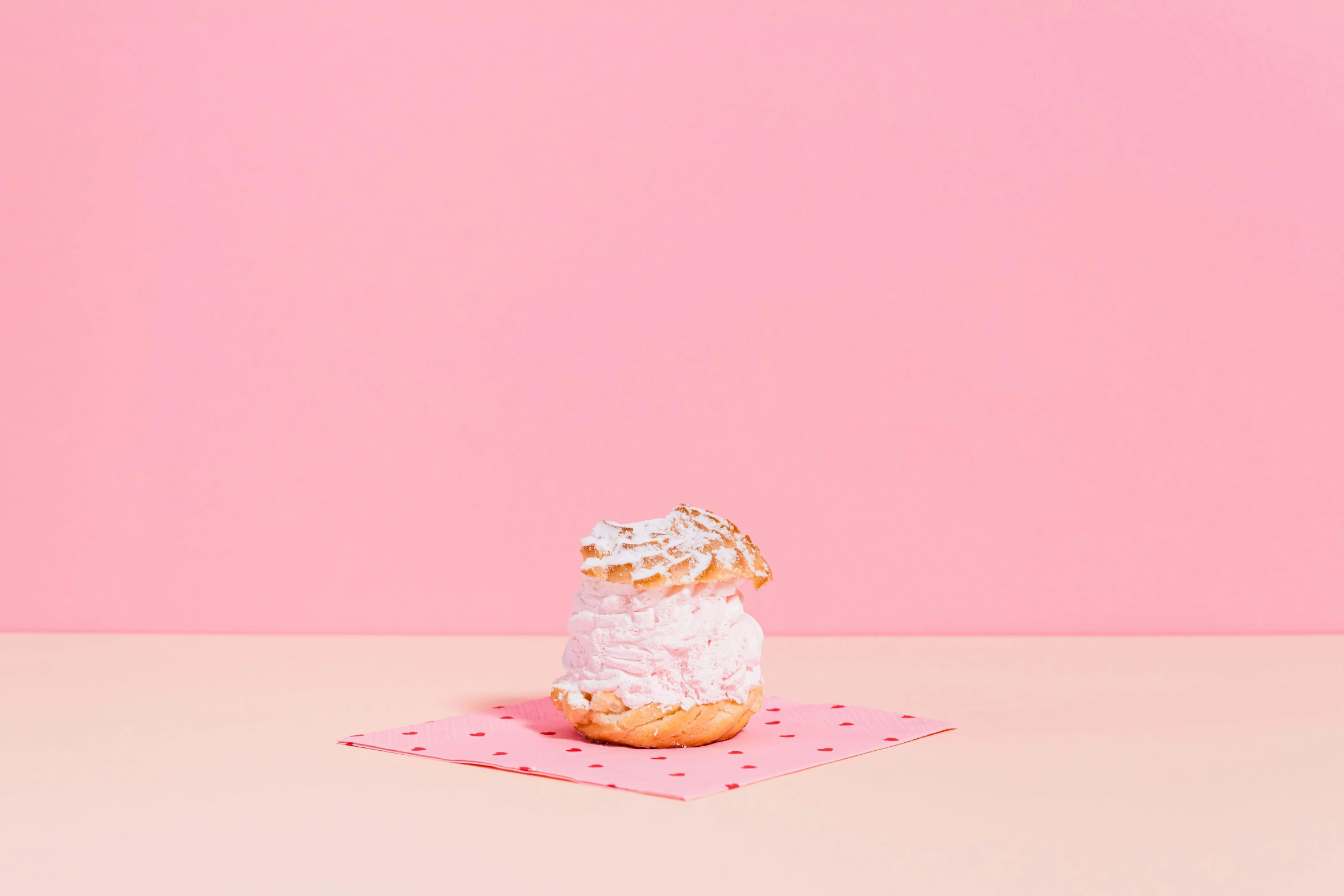 a donut sitting on top of a pink napkin, by Emma Andijewska, ice cream, small, ffffound, whipped cream on top