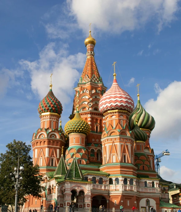 a group of people standing in front of a building, inspired by Vasily Surikov, pexels, socialist realism, cathedral, a green, turrets, red and brown color scheme