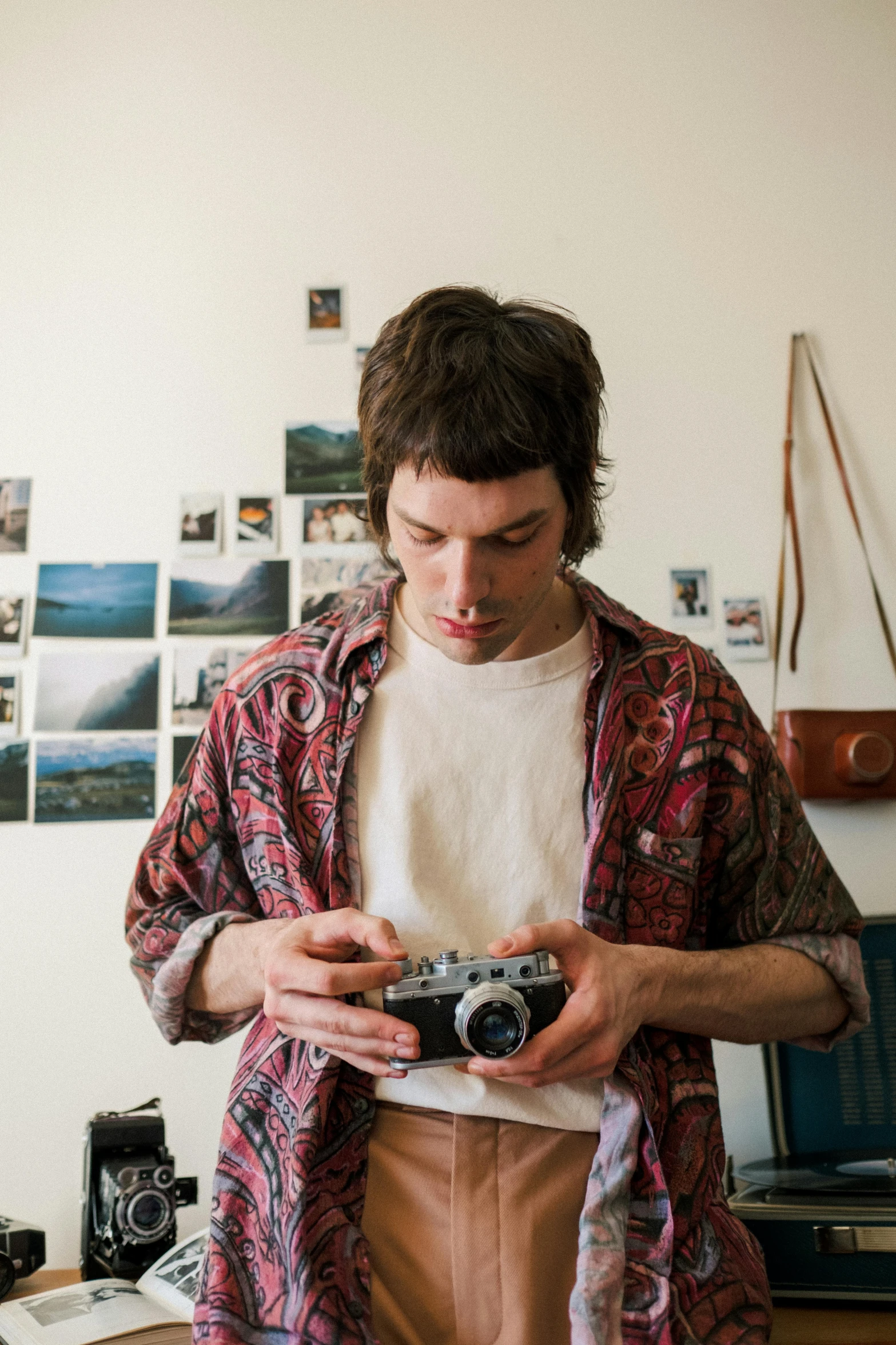 a man standing in a room holding a camera, a picture, by Penelope Beaton, adam ondra, close up portrait shot, indie, liam