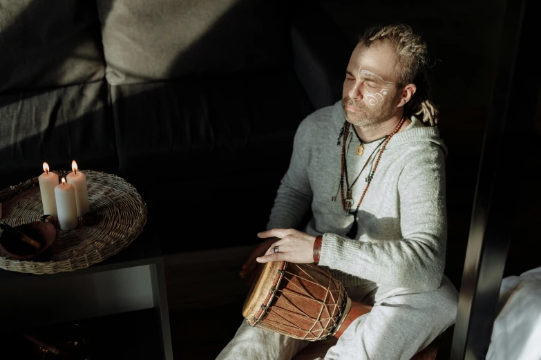 a man that is sitting down with a drum, inspired by Ásgrímur Jónsson, pexels contest winner, hurufiyya, kundalini energy, soft warm light, 15081959 21121991 01012000 4k, centered portrait