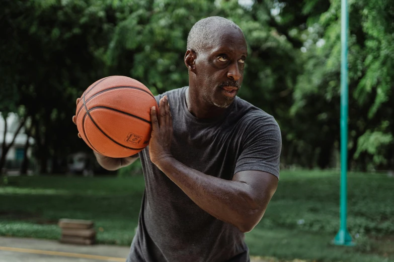 a man holding a basketball on a basketball court, lance reddick, wearing a muscle tee shirt, working out, profile image