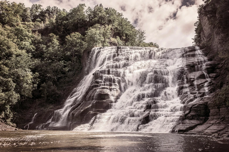 a large waterfall in the middle of a forest, an album cover, landscape photograph, chesley, 2022 photograph, endangered