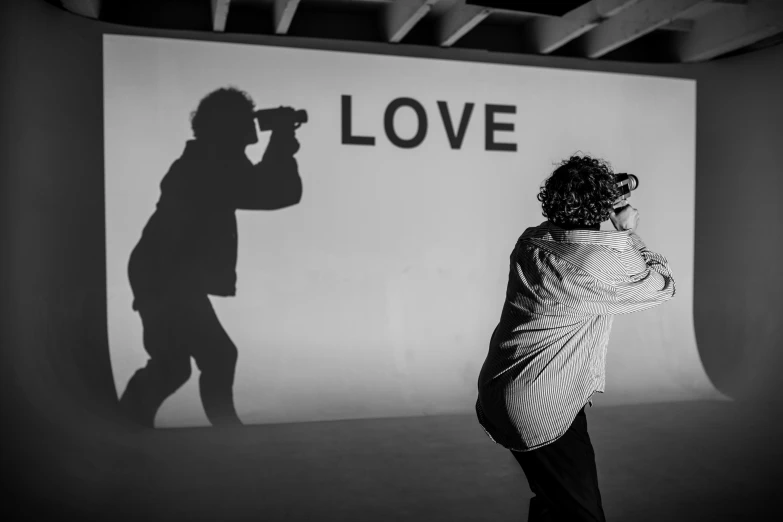 a woman taking a picture of a man with a camera, a black and white photo, by Jan Rustem, unsplash, graffiti, alec soth : : love, live performance, shadow, zack de la rocha