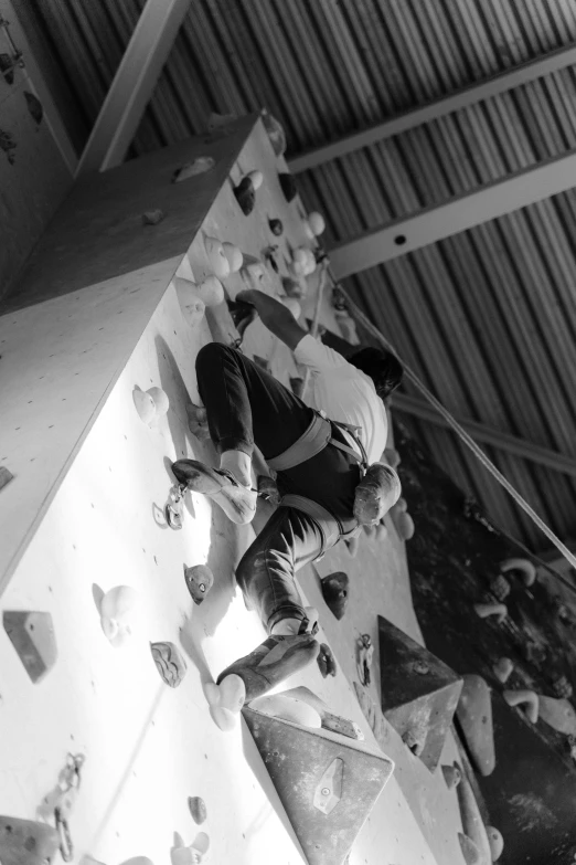 a black and white photo of a man on a climbing wall, jason chan and gilles beloeil, matoko shinkai, deep colour, indoors