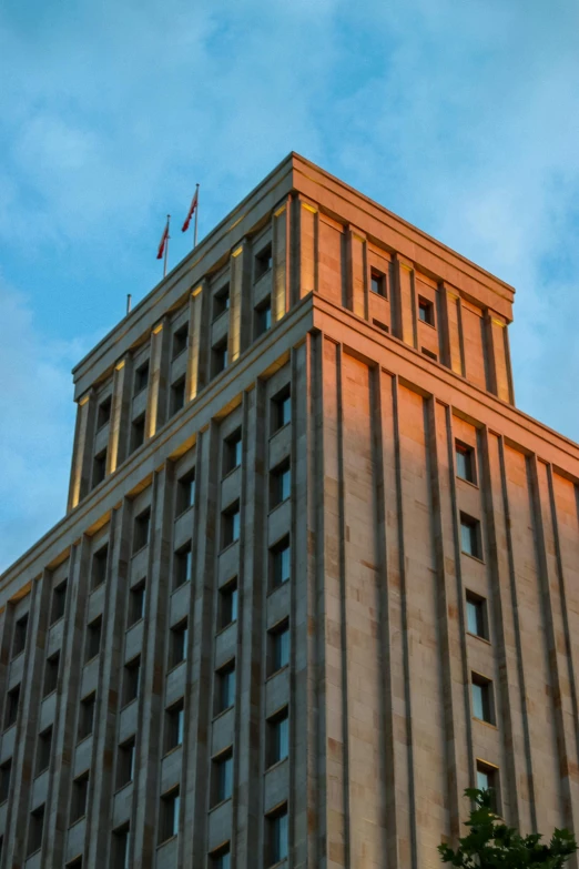 a tall building with a clock on top of it, sunset lighting ominous shadows, soviet brutalism, profile image, square