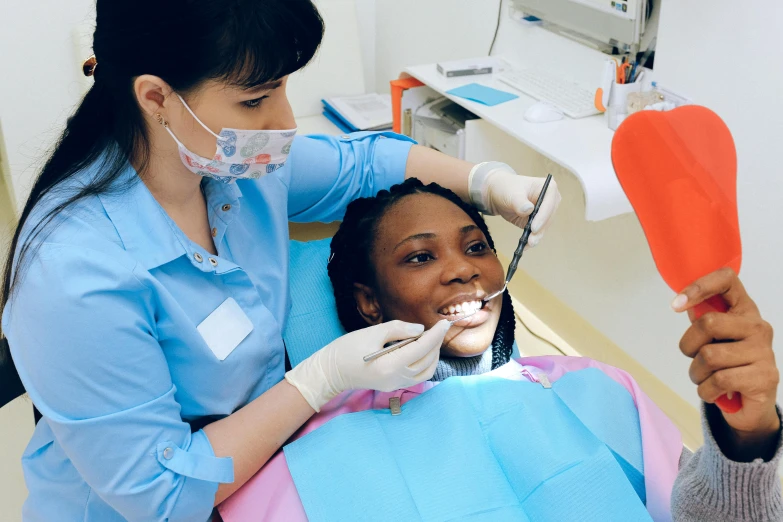 a woman getting her teeth examined by a dentist, a colorized photo, pexels contest winner, hurufiyya, photo of a black woman, youtube thumbnail, translucent gills, thumbnail