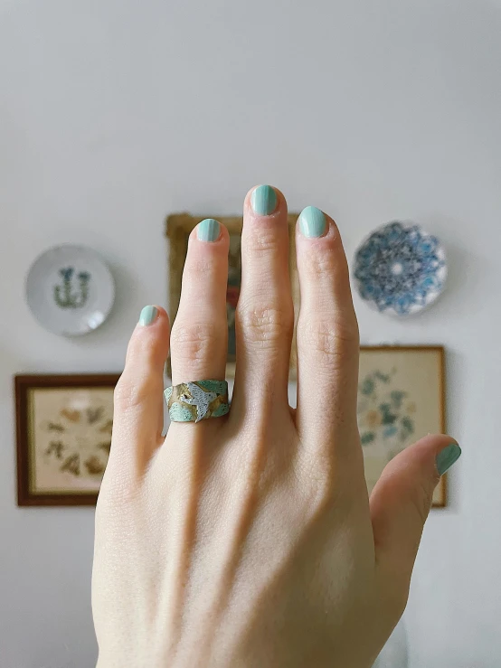 a close up of a person's hand with a ring on it, featured on pinterest, cloisonnism, pale cyan and grey fabric, full body in shot, display item, modeled