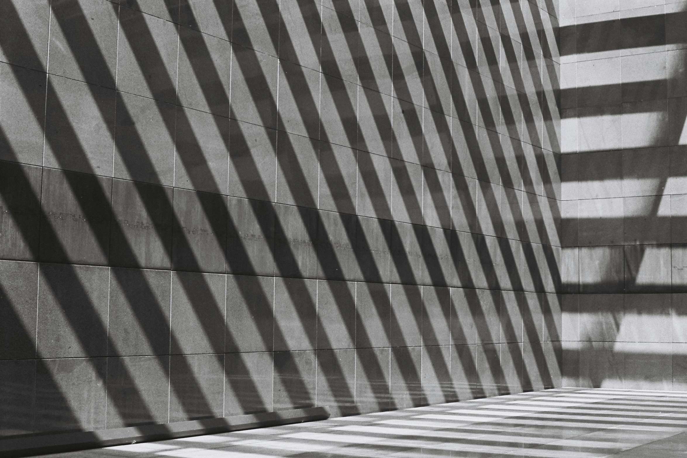 a black and white photo of a building, unsplash, op art, long cast shadows, made of stone and concrete, square lines, concrete _ wall ) ]