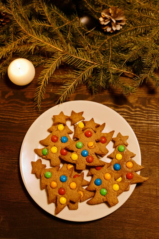 a white plate topped with cookies covered in m & m's, a still life, pexels, lightening tree, sweden, back, ginger