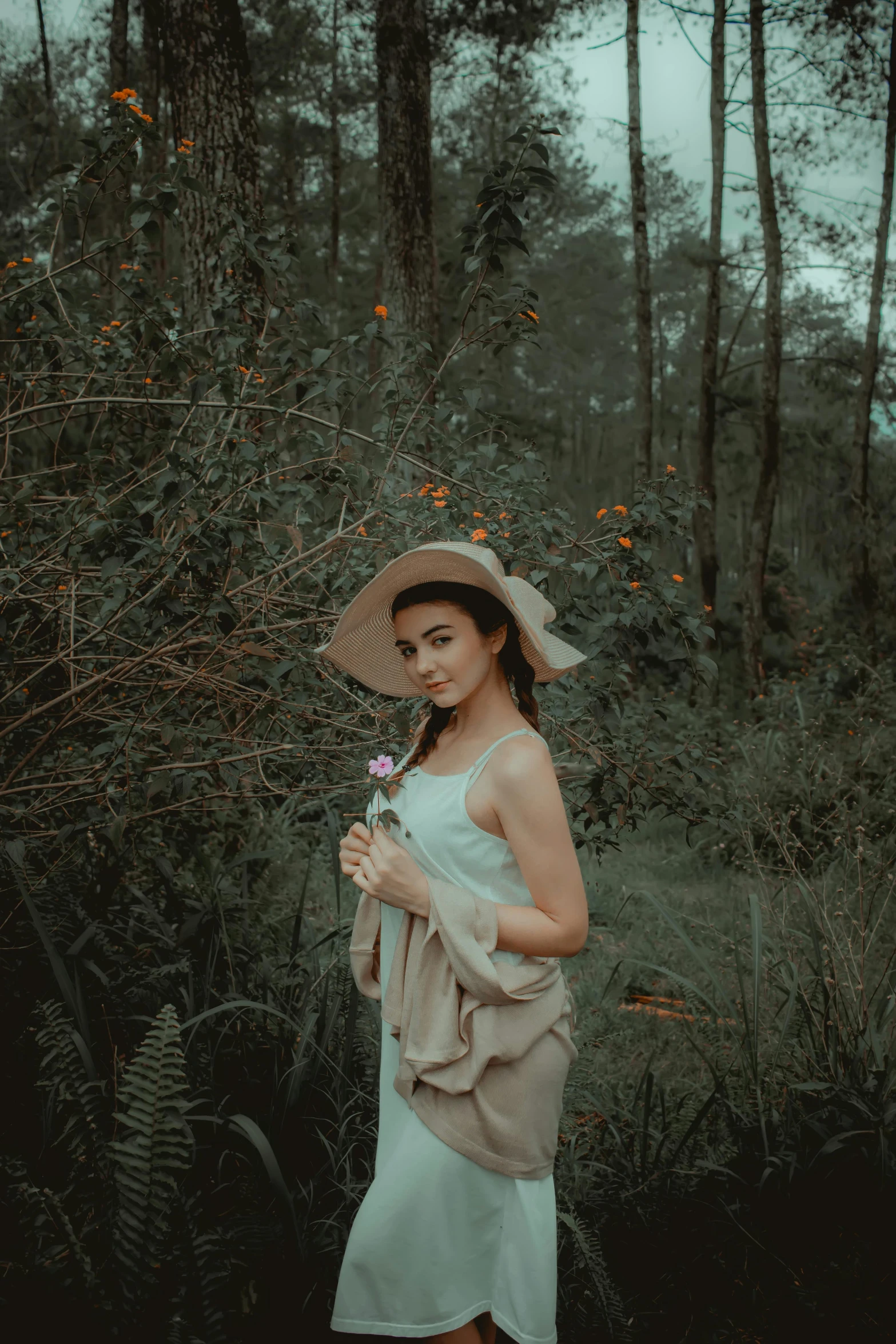 a woman standing in the middle of a forest, inspired by irakli nadar, sumatraism, wearing a cute hat, lily, low quality photo, high quality image