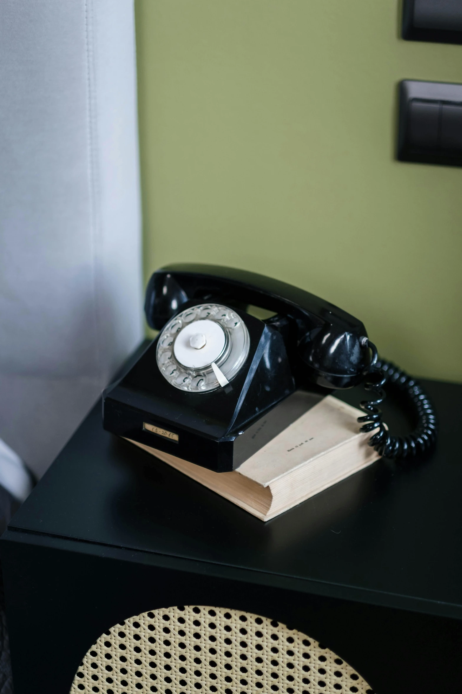 a black telephone sitting on top of a wooden table, hotel room, jen atkin, photograph credit: ap, technological rings