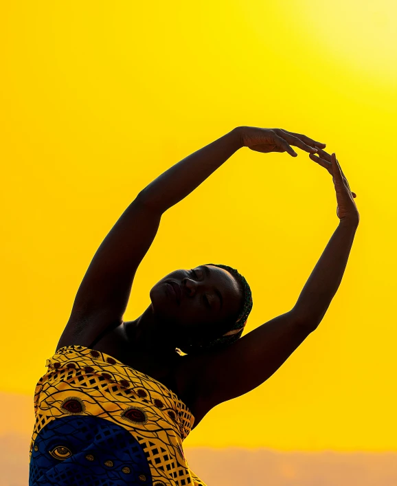 a woman standing on top of a beach holding a frisbee, by Carey Morris, pexels contest winner, afrofuturism, on yellow paper, yoga, african, hands raised