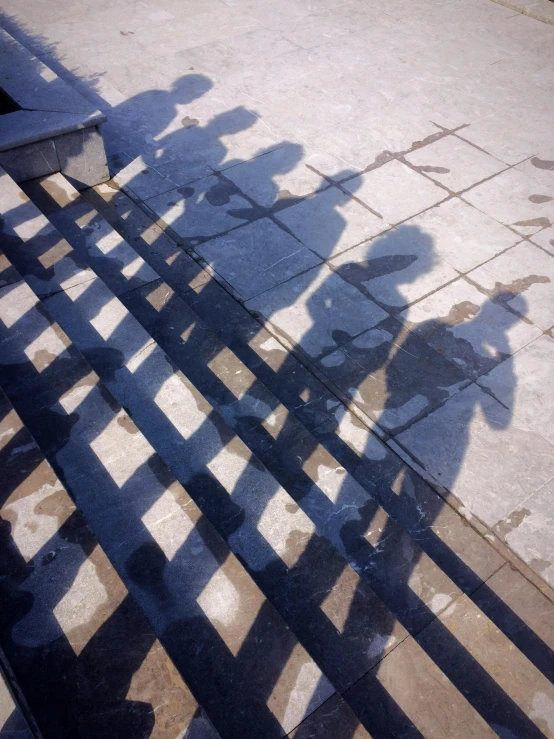 a group of people standing next to each other on a sidewalk, an album cover, by Yasushi Sugiyama, unsplash, detailed shadows, venice biennale, iphone picture, reflective chessboard