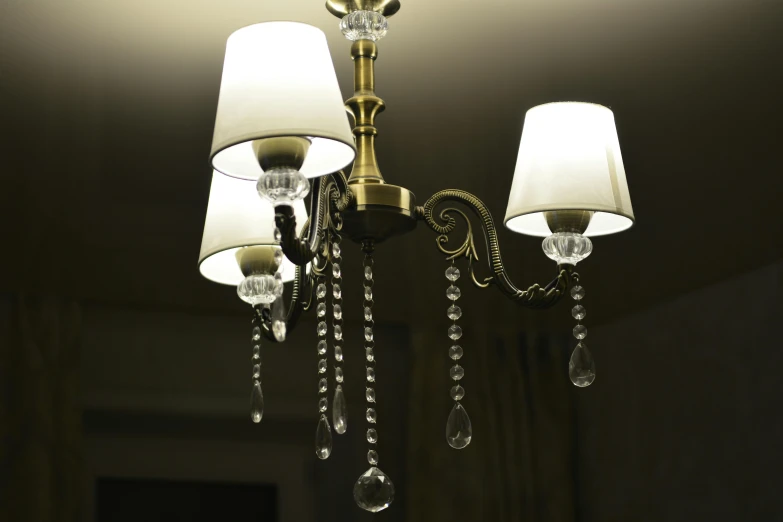 a close up of a chandelier with three lamps, pixabay, taken with a canon eos 5d, high-quality render, indoor dim light, brass plated