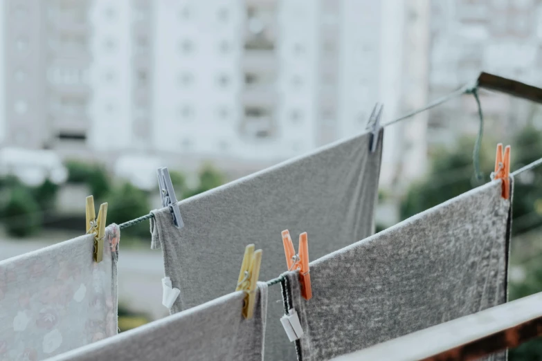 clothes hanging on a clothes line with buildings in the background, grey, flat grey