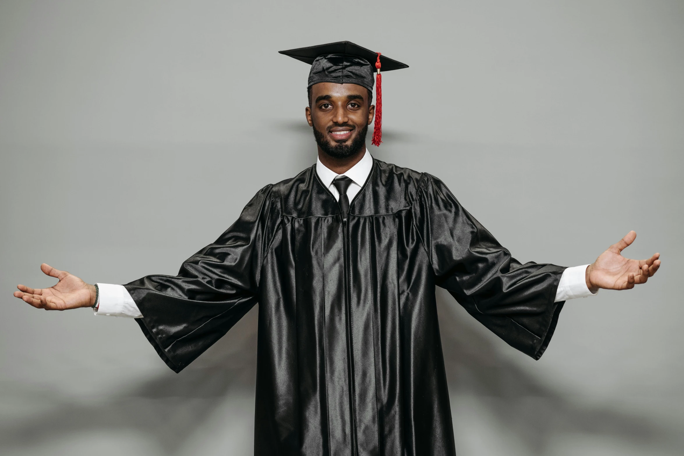 a man in a graduation gown posing for a picture, a portrait, pexels, jaylen brown, gray men, black, 2 0 2 2 photo