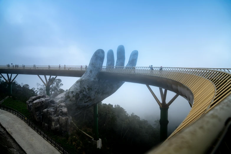 a close up of a person's hand on a bridge, a statue, inspired by Filip Hodas, interactive art, cloud forest, yellow volumetric fog, singapore, pewdiepie selfie at a bridge