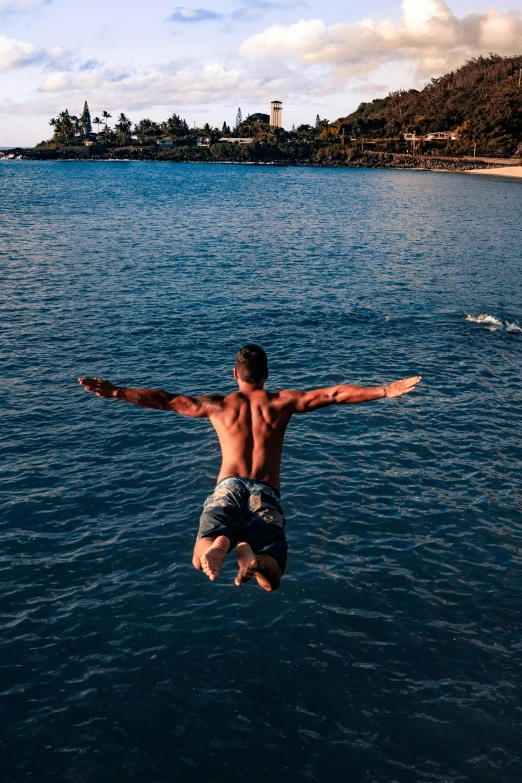 a man jumping into a body of water, posing in waikiki, body of water, viewed from the ocean, instagram post