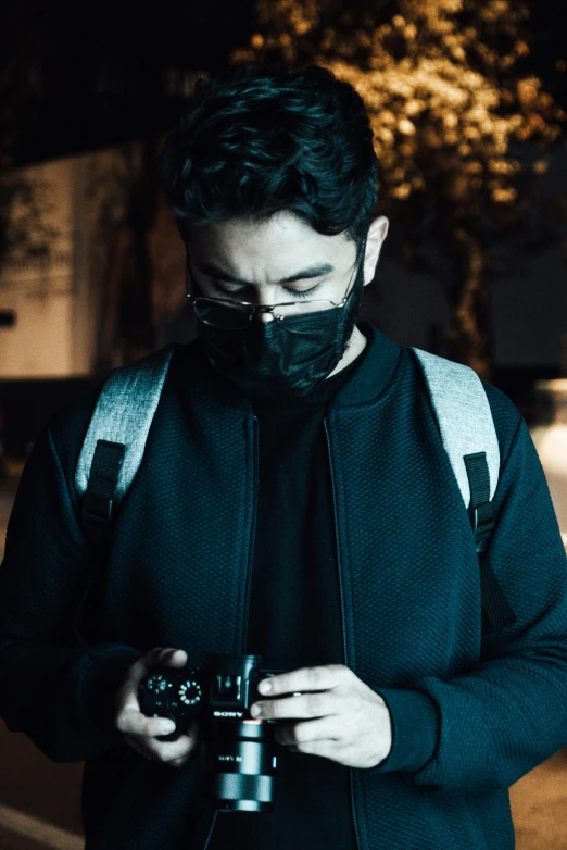 a man wearing a face mask holding a camera, by Alejandro Obregón, reddit, game ready, profile picture 1024px, dimly - lit, icon