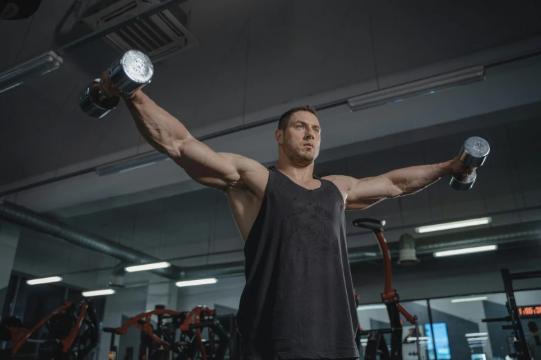 a man lifting two dumbbells in a gym, a portrait, by Adam Marczyński, pexels contest winner, muscular!! sci-fi, local gym, shoulder, bodybuilder ernest khalimov